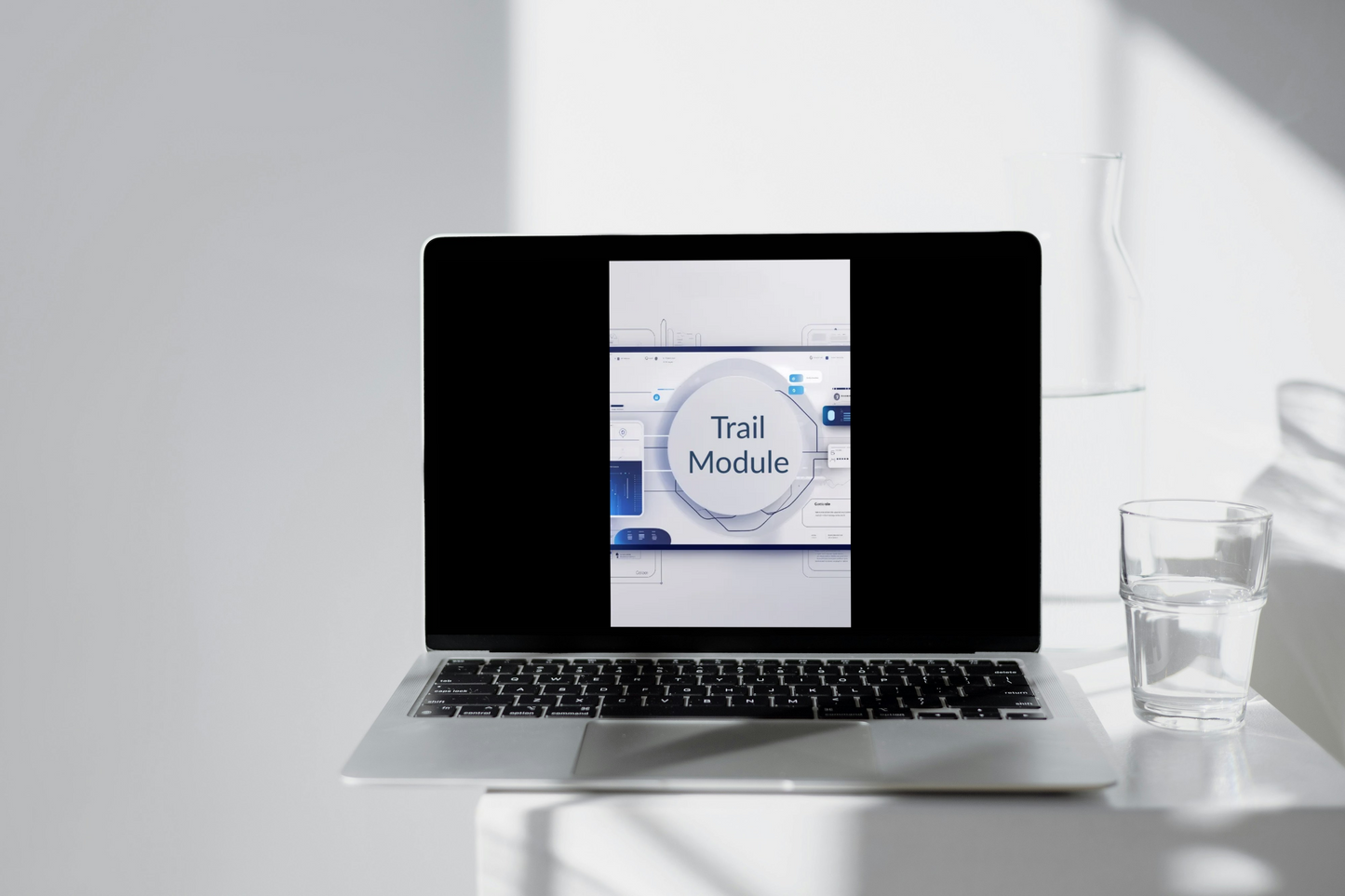 Laptop displaying the 'Trail Module' on a beige surface with shadows.