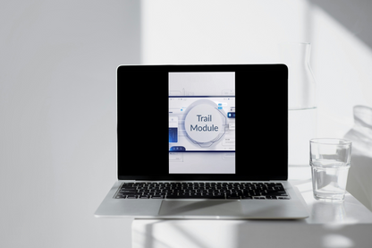 Laptop displaying the 'Trail Module' on a beige surface with shadows.
